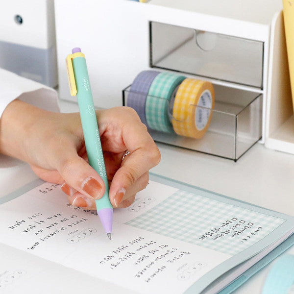 Mujer escribiendo en un planner semanal con un bolígrafo de gel de tinta negra