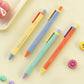 Cuatro bolígrafos de gel de colores vivos de la marca coreana Iconic junto a caritas sonrientes de colores