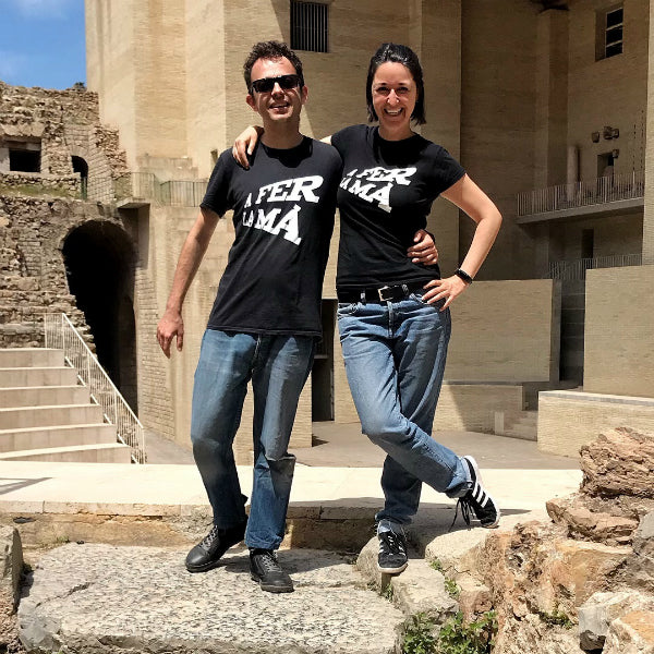 Pareja con la camiseta negra de A fer la má en el Teatro Romano de Sagunto, en Castellón