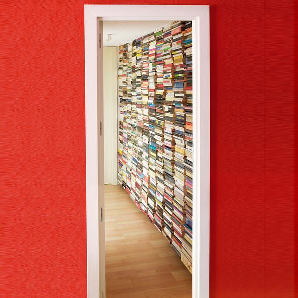 Pared forrada de libros gracias a una combinación de estanterías metálicas verticales en la pared