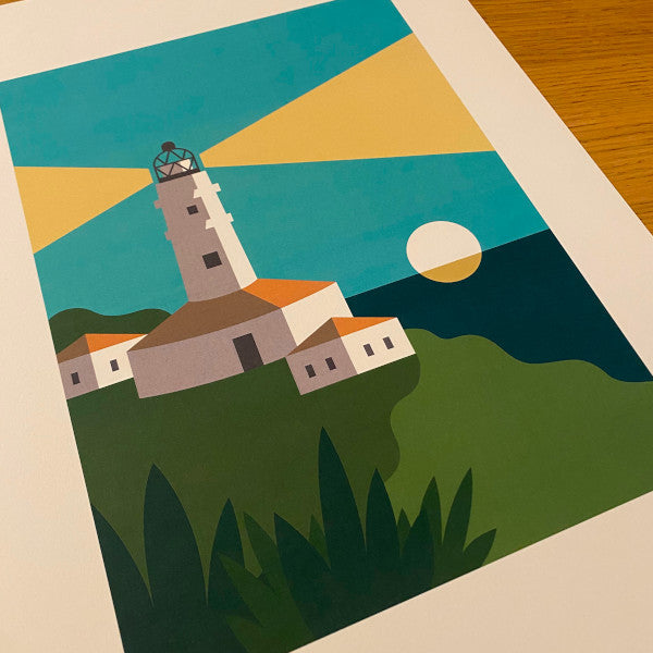 Detalle de la ilustración de Elisa Talens con un faro encendido al atardecer, con el sol poniéndose en el mar de fondo y casitas y vegetación en primer plano