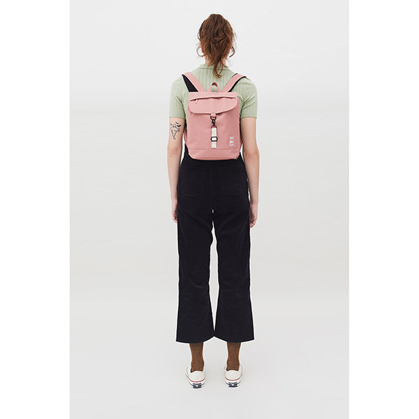 Mujer de espaldas con el pelo recogido y una mini mochila rosa de Lefrik