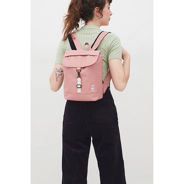 Mujer de espaldas con el pelo recogido y una mini mochila rosa de Lefrik