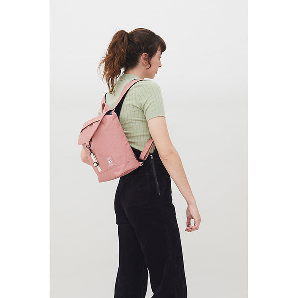Mujer de espaldas con un mono negro y una mini mochila rosa de Lefrik