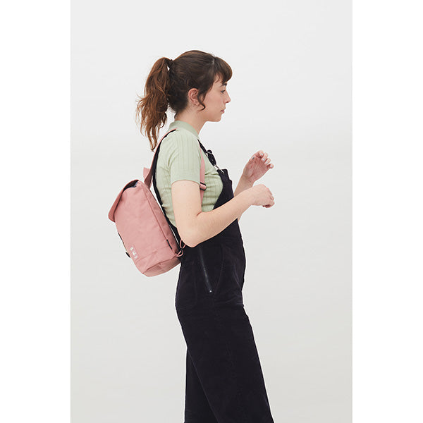 Mujer de espaldas con un mono negro y una mini mochila rosa de Lefrik