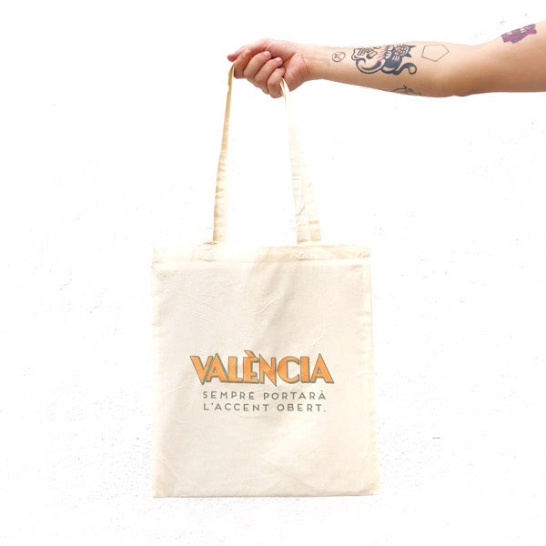 Bossa tote bag blanca amb la frase en valencià "València sempre portarà l'accent obert" dissenyada per Vir Palmera