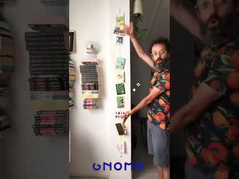 Un hombre enseña cómo queda el fotocable con imanes con muchas postales colgadas.