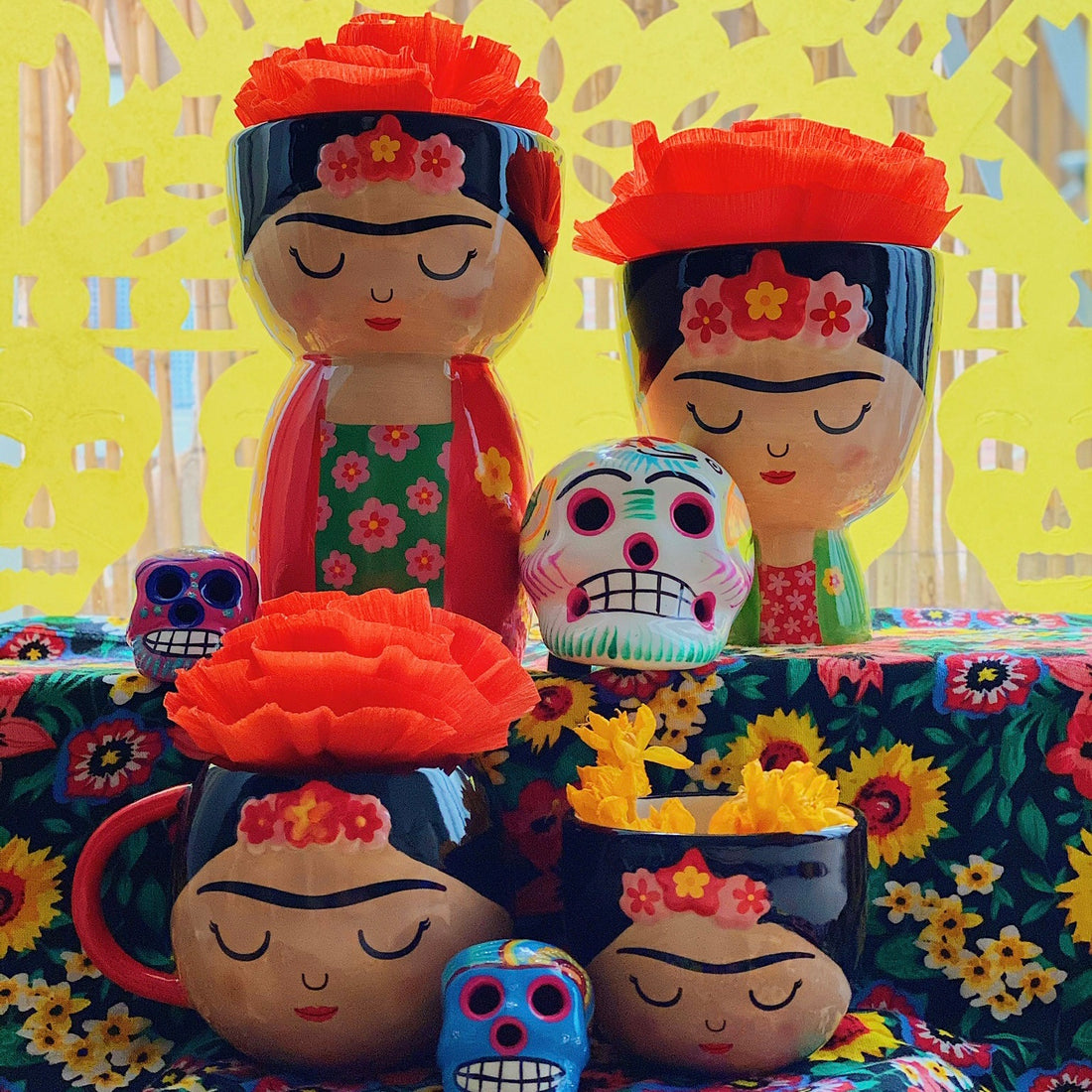 Macetas con la figura de Frida Kahlo sobre un altar de Día de Muertos