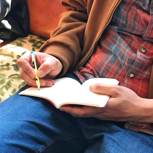 Libreta y lápiz sobre mesa, papelería de diseño en Gnomo Valencia