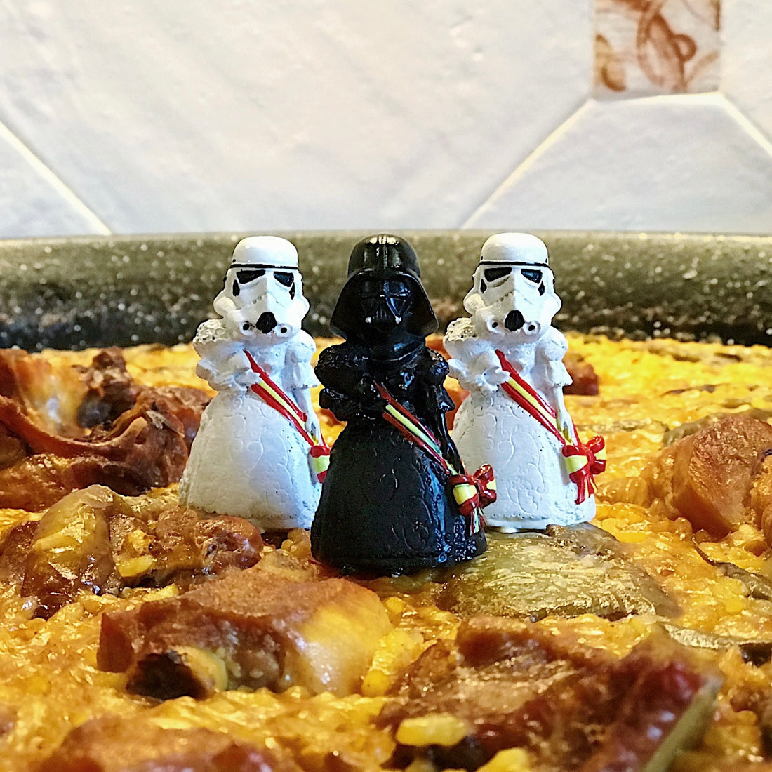 Storm trooper y Darth Vader vestidos con traje de paella encima de una paella