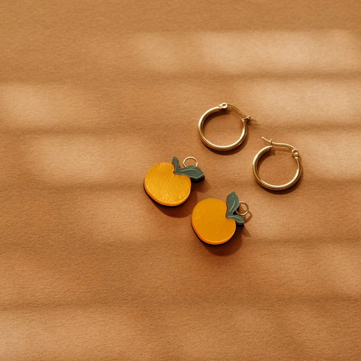 detalle de pendientes de aro en forma de naranjas de la artista mitumi