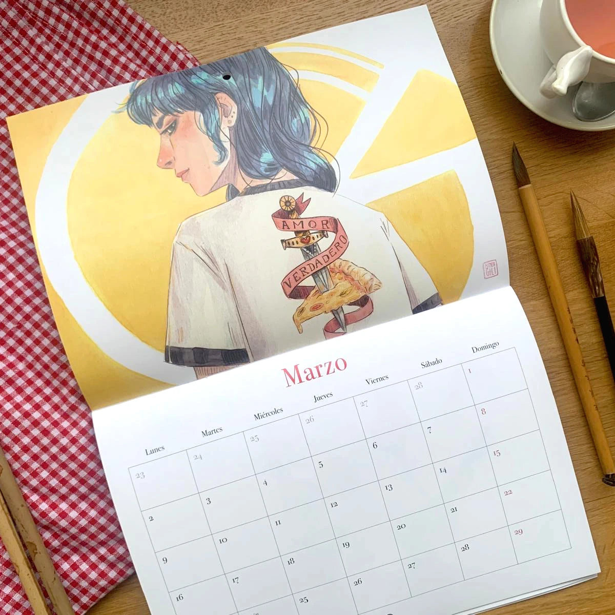 Diseño del mes de marzo del Calendario de pared 2026 de Esther Gili, Marialu Gili y Lady Desidia con ilustración de Esther Gili de una chica de espaldas  con una camiseta de Amor Verdadero a una pizza