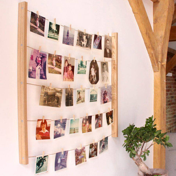 Marco Hangit colgado en una pared decorando con fotos enganchadas en cuerdas con pinzas