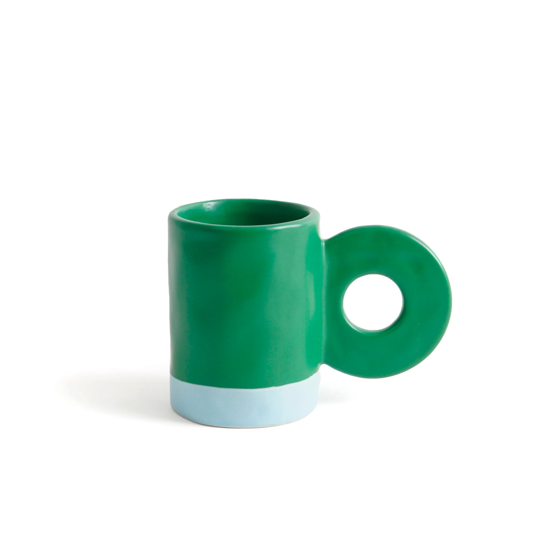 taza de cerámica de color verde de Helio Ferretti con la base de color azul celeste, con asa grande en forma de círculo 