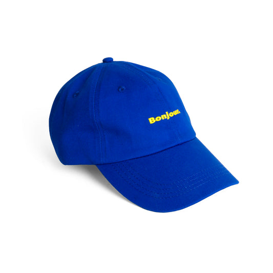 gorra ajustable de Helio Ferretti en color azul con el texto Bonjour en amarillo
