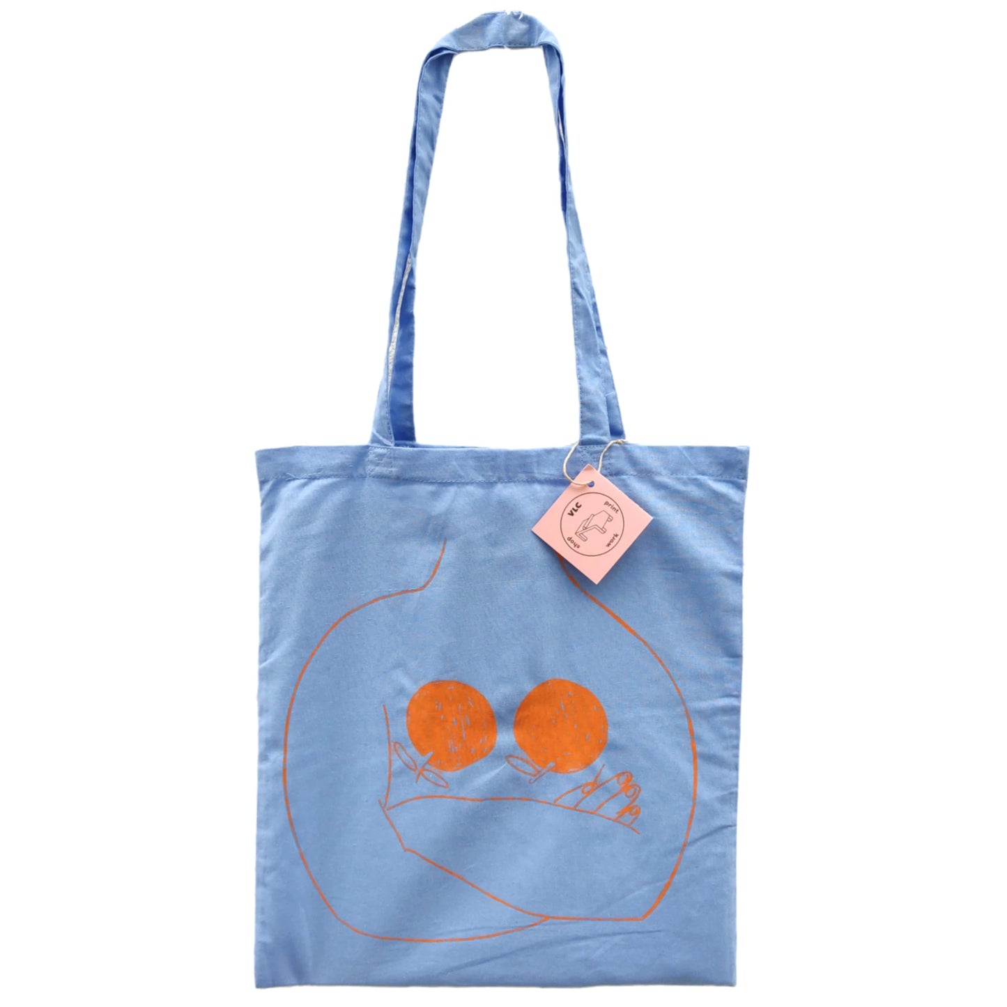 totebag de color azul con una ilustración de una persona cruzada de brazos con dos naranjas en el pecho