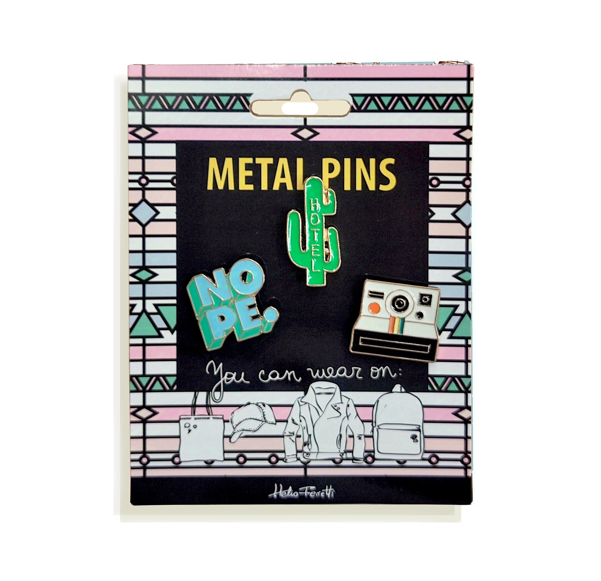 conjunto de tres pines de metal de Helio Ferretti en una tarjeta de cartón de colores rosa, azul y blanco con un patrón de figuras geométricas, con un diseño de una cámara polaroid, un cactus con la palabra HOTEL y la palabra NOPE.