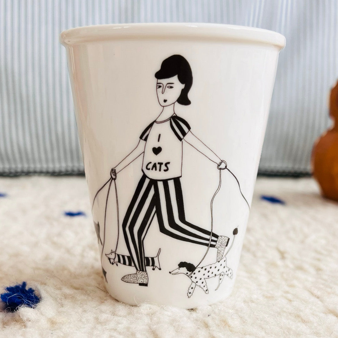 Vaso con ilustración de una chica paseando muchos perros con una camiseta en la que pone "I love cats"