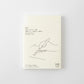 Agenda Midori MD 2027 A6 con funda de plástico transparente mostrando la portada ilustrada con una mano escribiendo "2027"