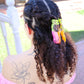 Chica de espaldas con trenzas sujetas con una pinza para el pelo de colores con forma de caracol dejando rastro de arcoiris