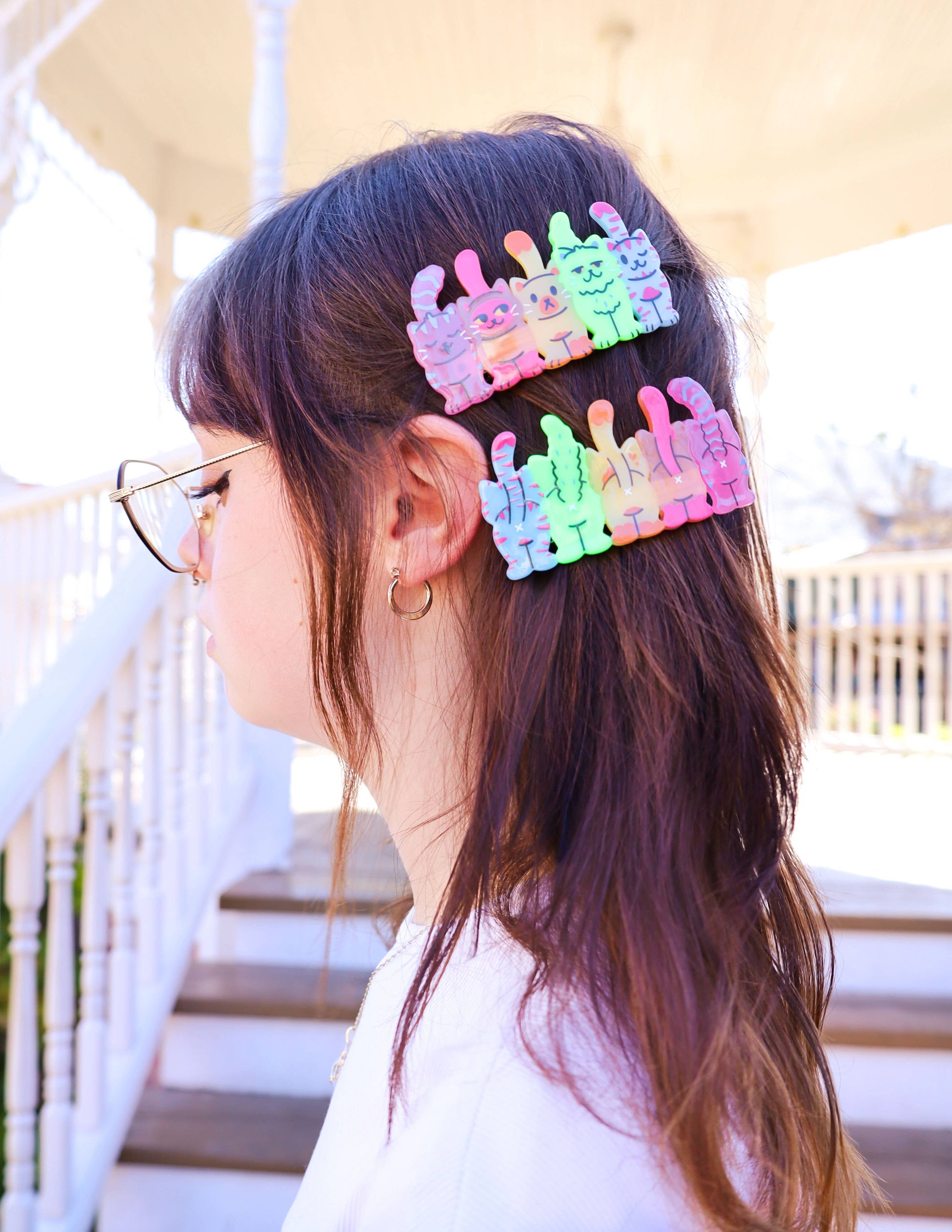 Chica con gafas y pinzas para el pelo con cinco gatos vistos desde alante y desde atrás