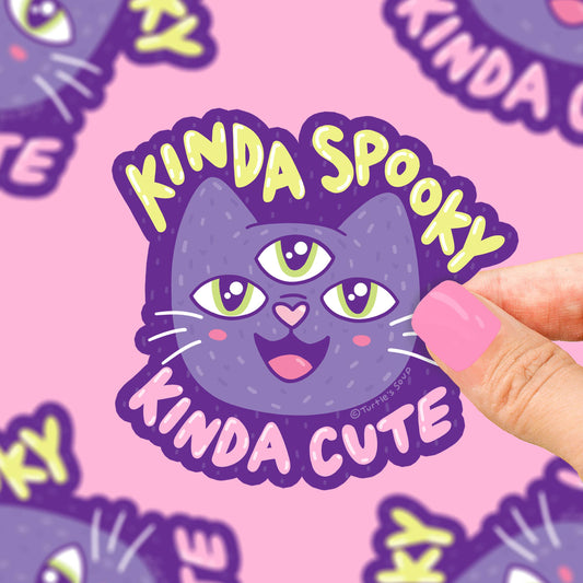 Pegatina con forma de gato de tres ojos y la frase "kinda spooky kinda cute"
