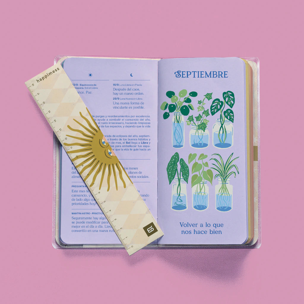 Agenda Happimess Astro abierta en septiembre con regla marcapáginas dorada con sol y páginas de plantas