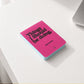 Mesa de trabajo con un bloc de notas con portada rosa fucsia y la frase Things I Should be doing, But I'm Not
