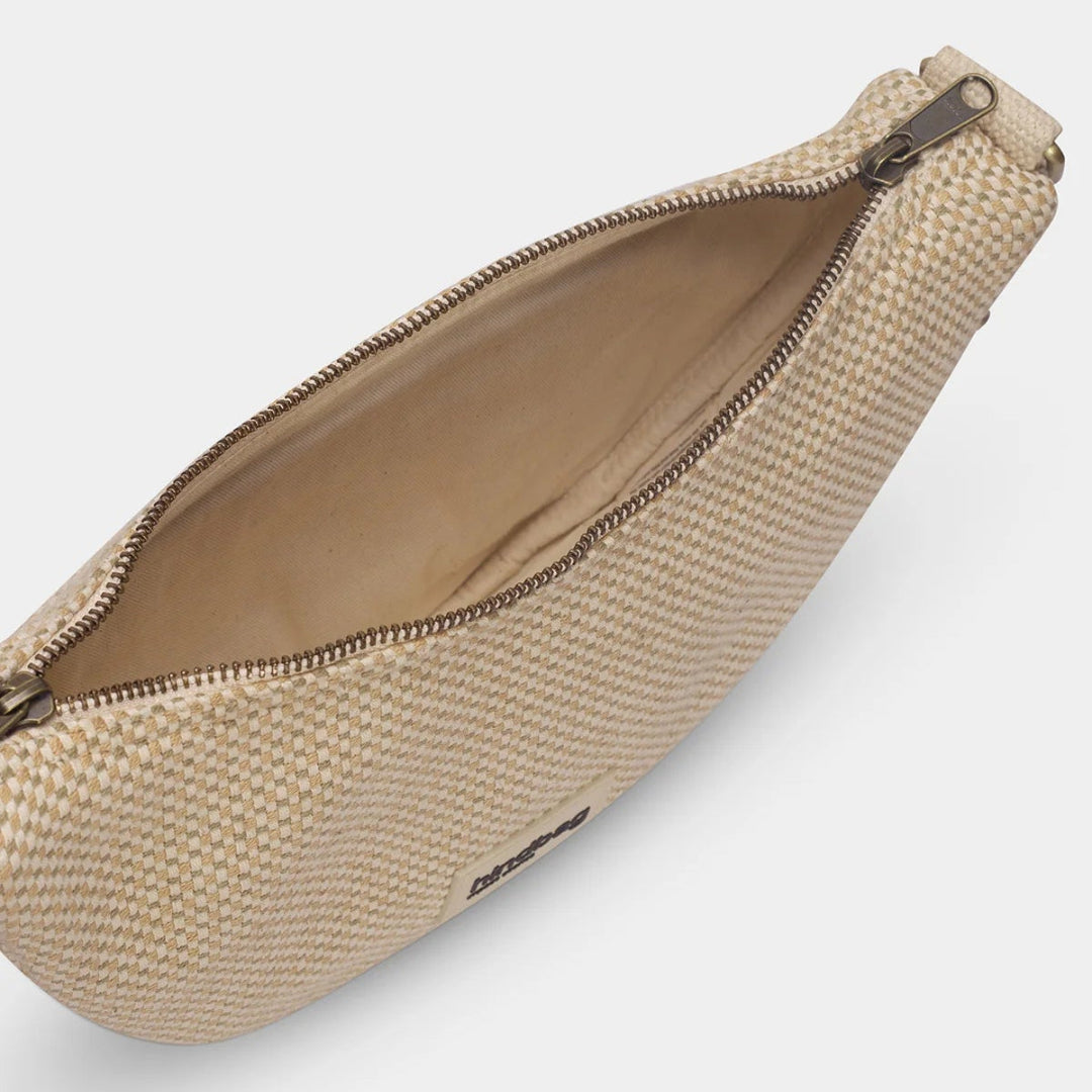 Interior del bolso en forma de media luna de tejido trenzado en tonos beige y nude de la marca francesa Hindbag