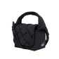 Mini bolso acolchado Ani de Lefrik en negro con asa superior acolchada y tejido trenzado en la solapa, fondo blanco