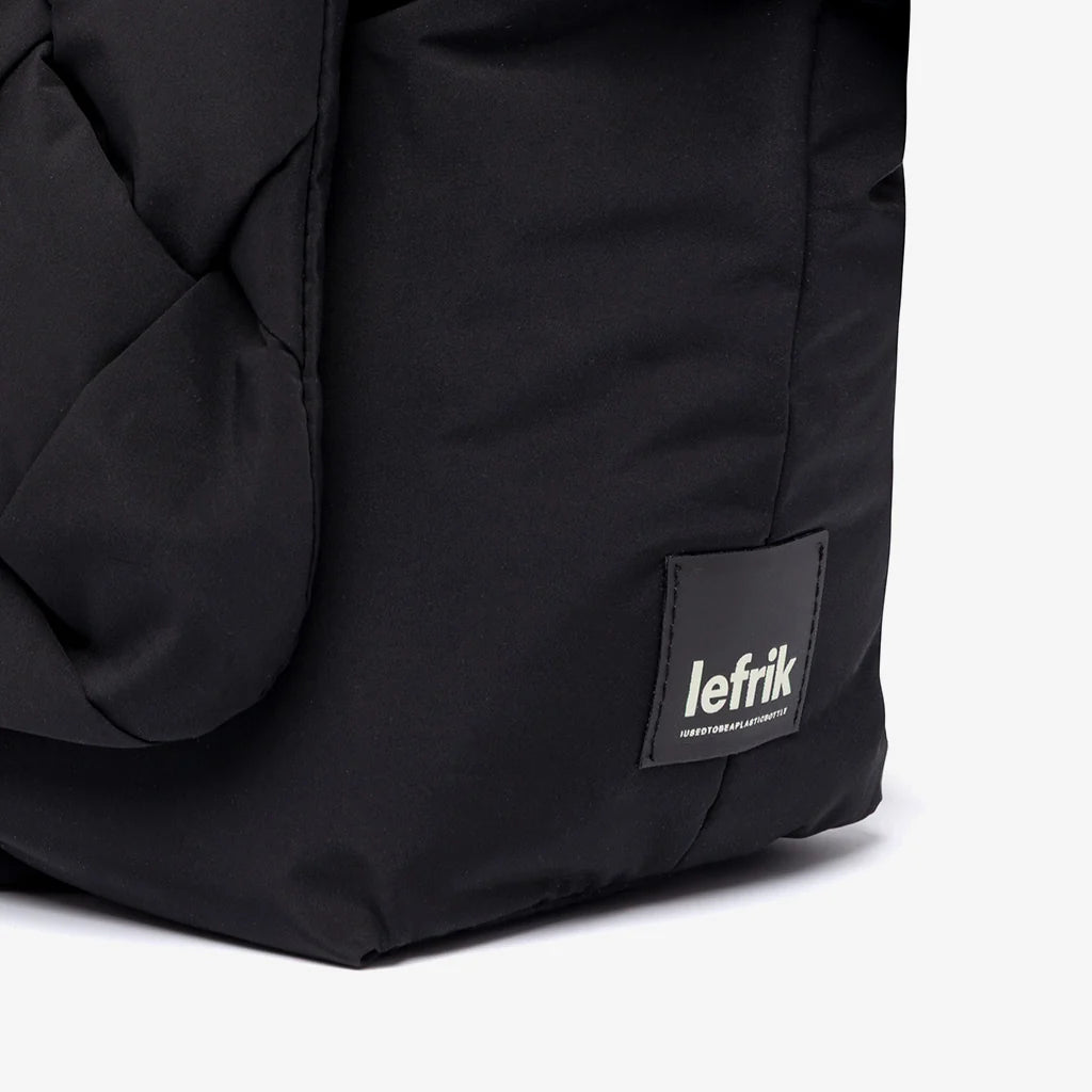 Detalle de la etiqueta Lefrik con texto "I used to be a plastic bottle" en el bolso Ani mini negro