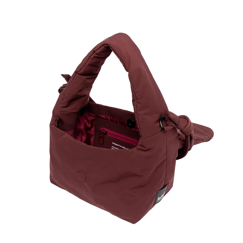 Interior del mini bolso Ani de Lefrik en burdeos con compartimento principal abierto y bolsillo interior con cremallera rosa