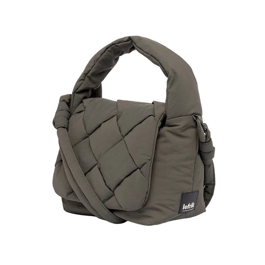 Vista lateral del bolso Ani mini de Lefrik en verde musgo con detalle del tejido trenzado y etiqueta Lefrik, asa en la mano