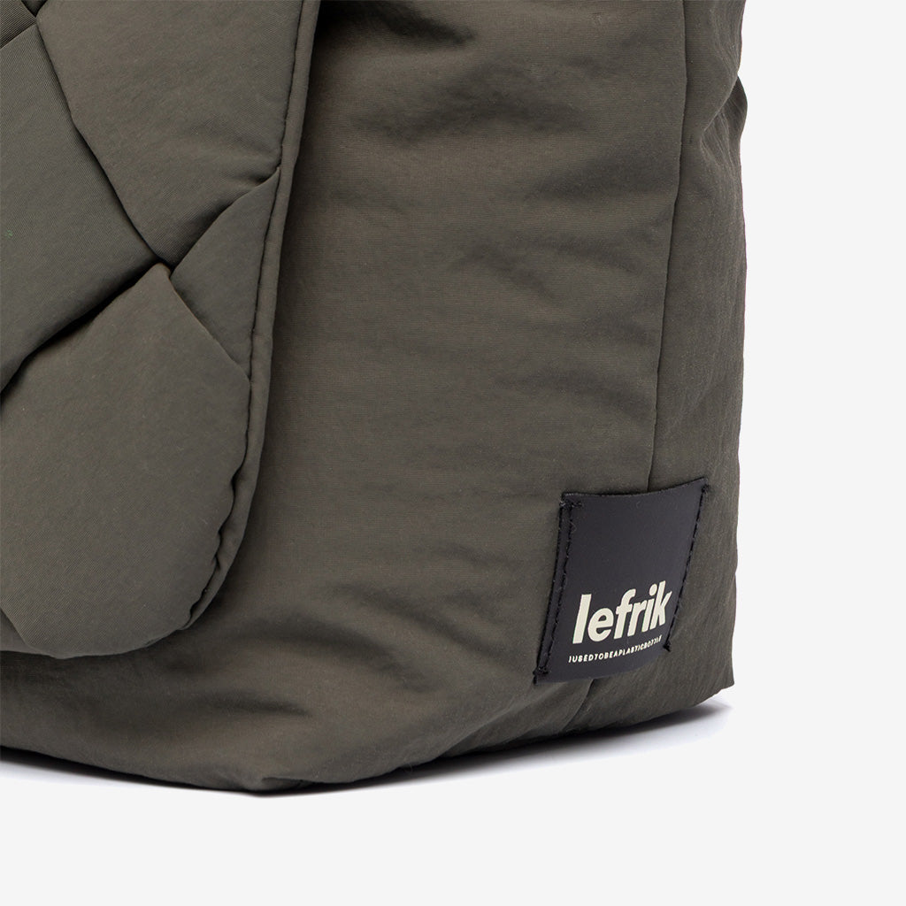 Detalle de la esquina inferior del bolso Ani mini de Lefrik en verde musgo con etiqueta de marca y tejido trenzado