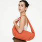 Mujer con el bolso mini naranja acolchado de lefrik al hombro