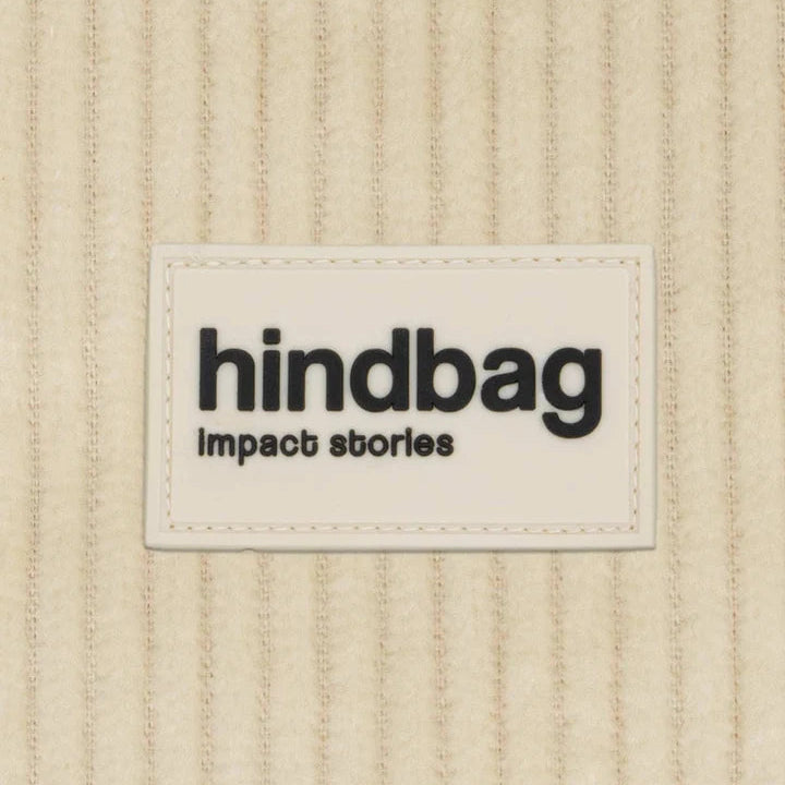 Detalle del material y la marca del bolso riñonera con cremallera de la marca francesa Hindbag de pana color beige