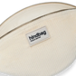 Primer plano del bolso riñonera con la cremallera abierta de la marca francesa Hindbag de pana color beige