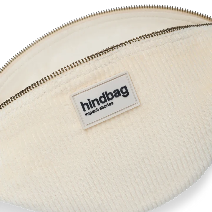 Primer plano del bolso riñonera con la cremallera abierta de la marca francesa Hindbag de pana color beige