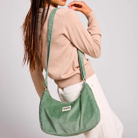 Mujer con un bolso de pana color verde agua cruzado de la marca francesa Hindbag