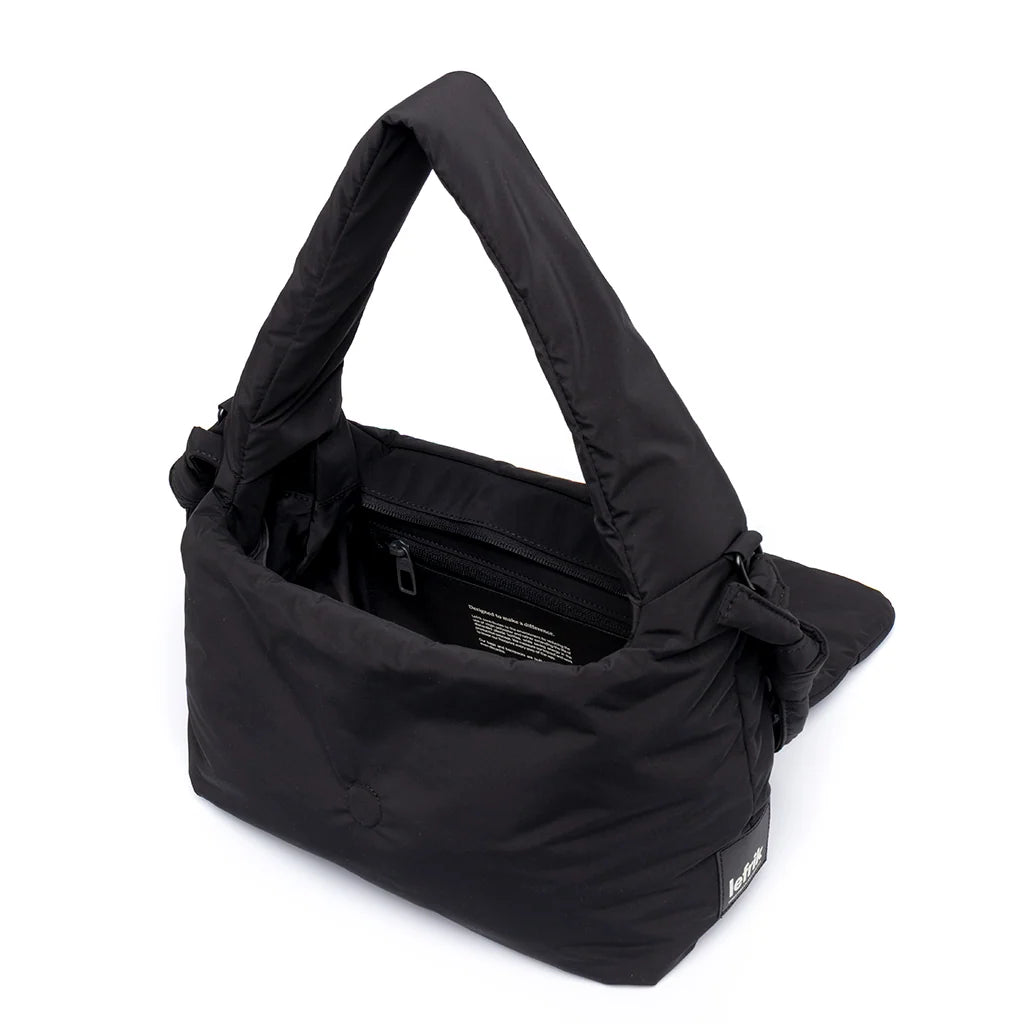 Interior del bolso negro Ani de Lefrik con la solapa abierta, compartimento principal y bolsillo interior con cremallera.
