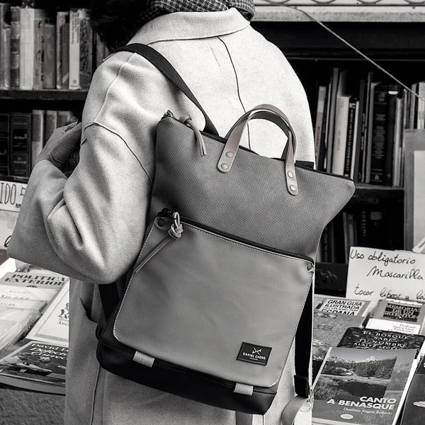 Persona en blanco y negro con la mochila book holder de daniel chong a la espalda