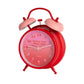 detalle del reloj en estilo retro de la marca Fisura en color rojo y con detalles en rosa, con el texto better late than ugly sobre fondo blanco