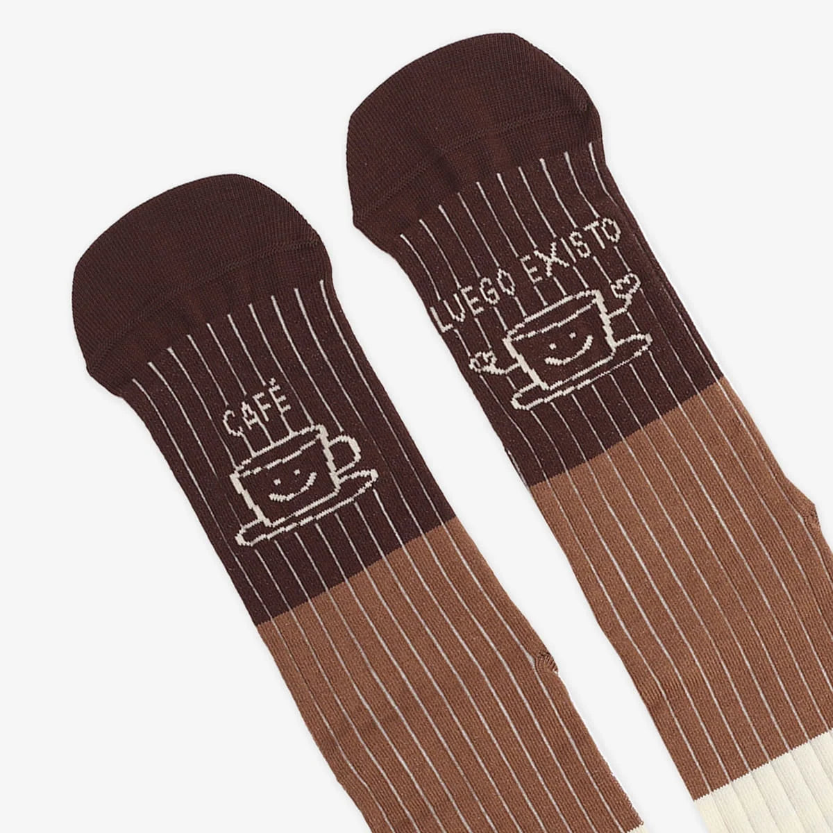 Detalle de las tazas sonrientes y el mensaje «Café, luego existo» sobre las punteras marrones de los calcetines UO.