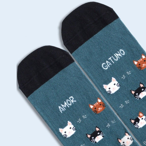 Primer plano de las punteras de los calcetines con estampado de gatos y el mensaje Amor Gatuno