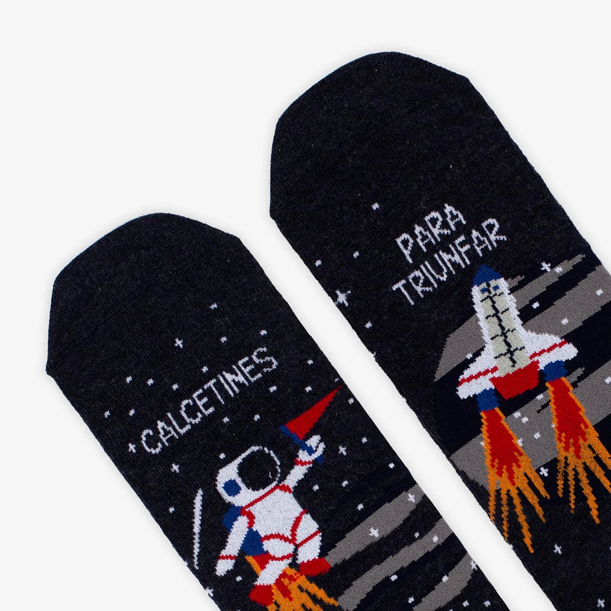 Detalle de la punta de los calcetines estampados con un astronauta y una nave espacial y el mensaje "Calcetines / para triunfar"