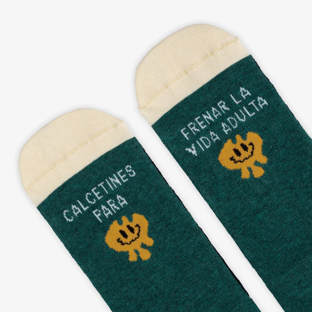 Detalle de los calcetines verde botella con un monigote amarillo y el mensaje "Calcetines para / frenar la vida adulta"