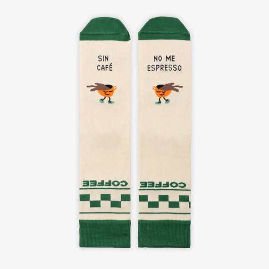 Calcetines beige con puntera y goma verde y una taza de café con carita con el mensaje "Sin café no me espresso"