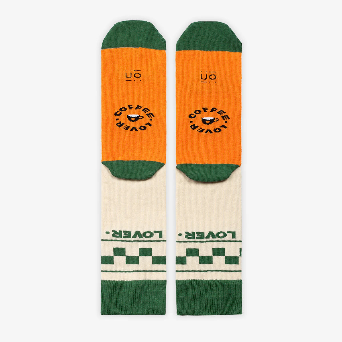 Parte de atrás de los calcetines beige con puntera y goma verde con el mensaje "Sin café no me espresso" con suela naranja y las palabras "coffee lover"