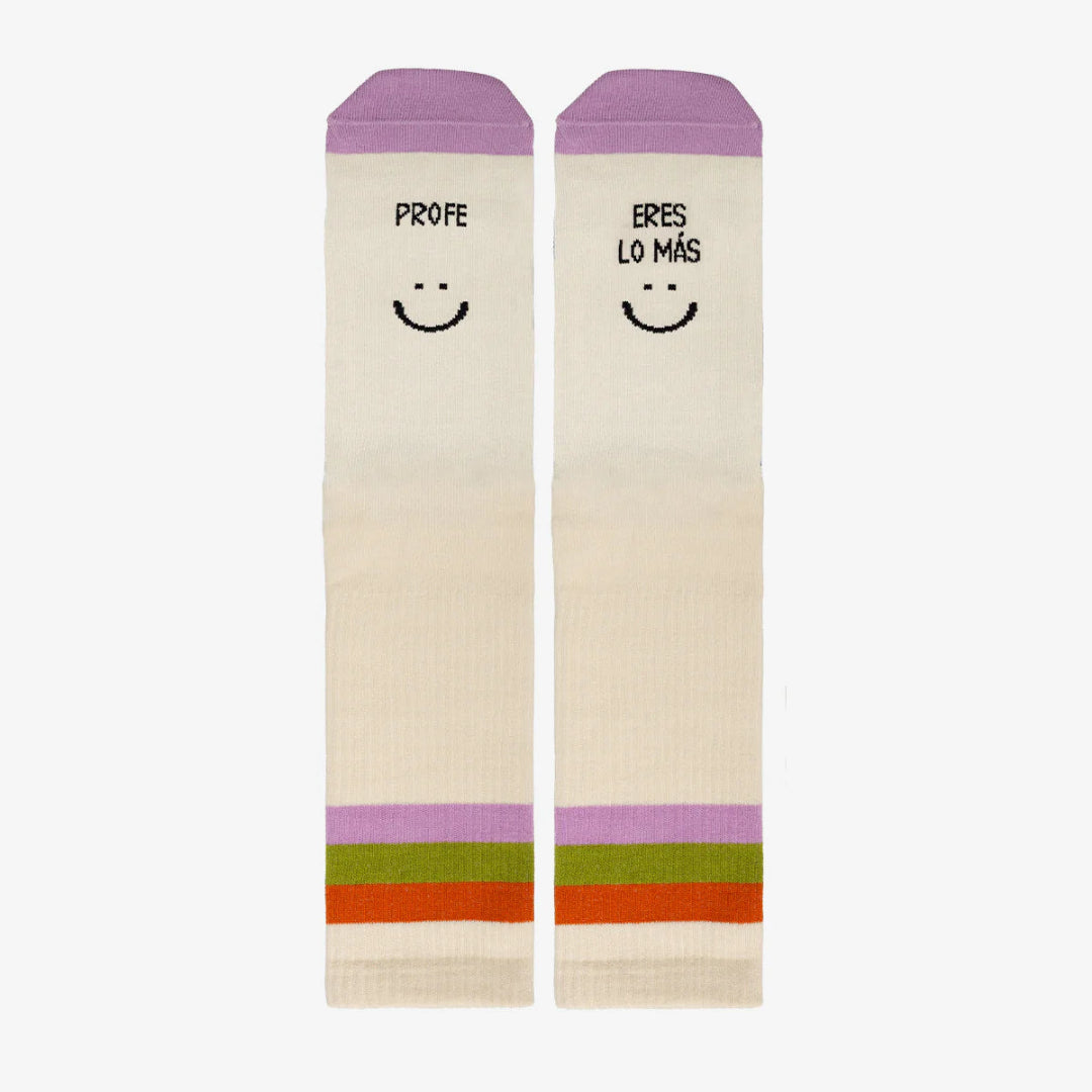 Calcetines beige con detalle morado en la puntera y el mensaje Profe eres lo más :) y tres franjas en la caña naranja, verde y lila