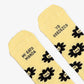 Detalle de la puntera de los calcetines amarillos con estampado de caras de gato y el mensaje "Mi gato manda / yo obedezco"